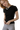 A woman wearing a black short-sleeve t-shirt with delicate pointelle detailing and a necklace.